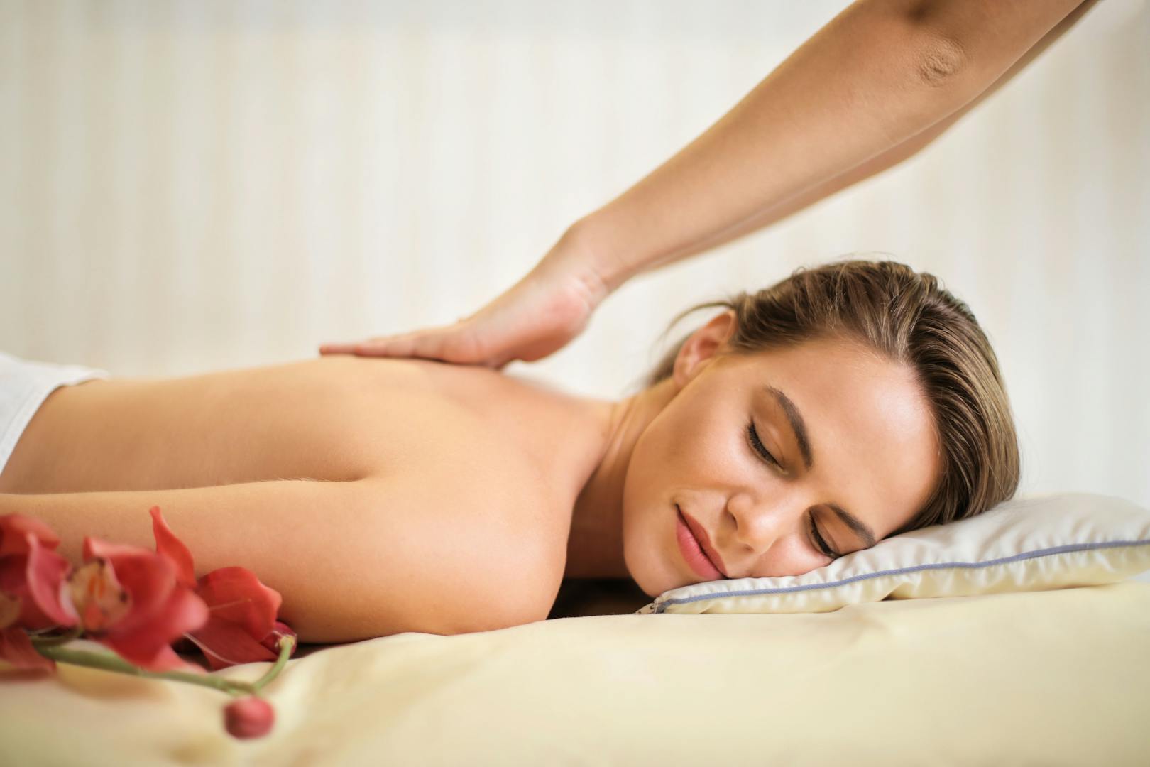 Une scène de spa sereine mettant en vedette une femme recevant un massage thérapeutique, entourée d'éléments apaisants.